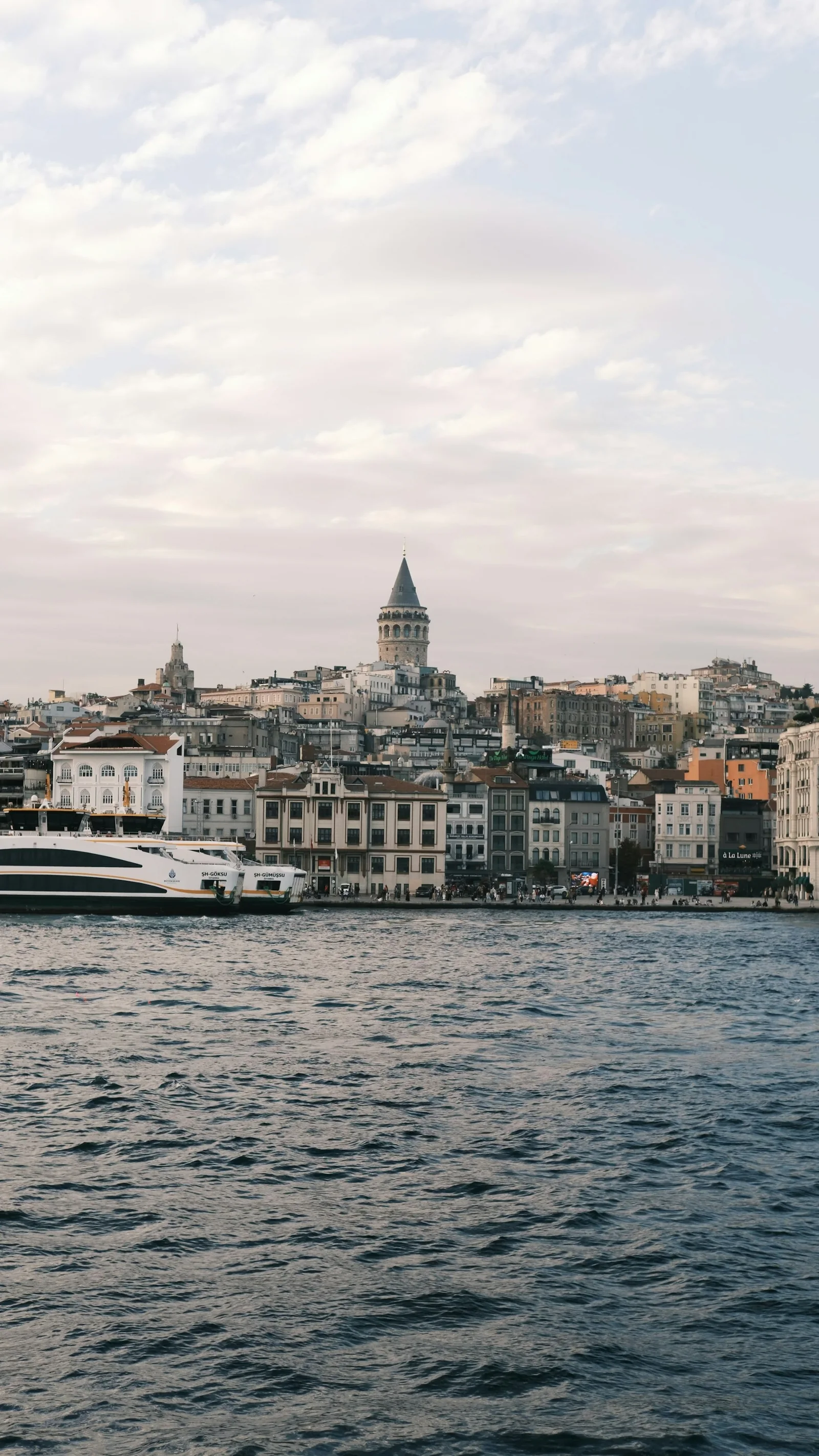 Galata Tower above Istanbul's waterfront, with a ferry in the foreground