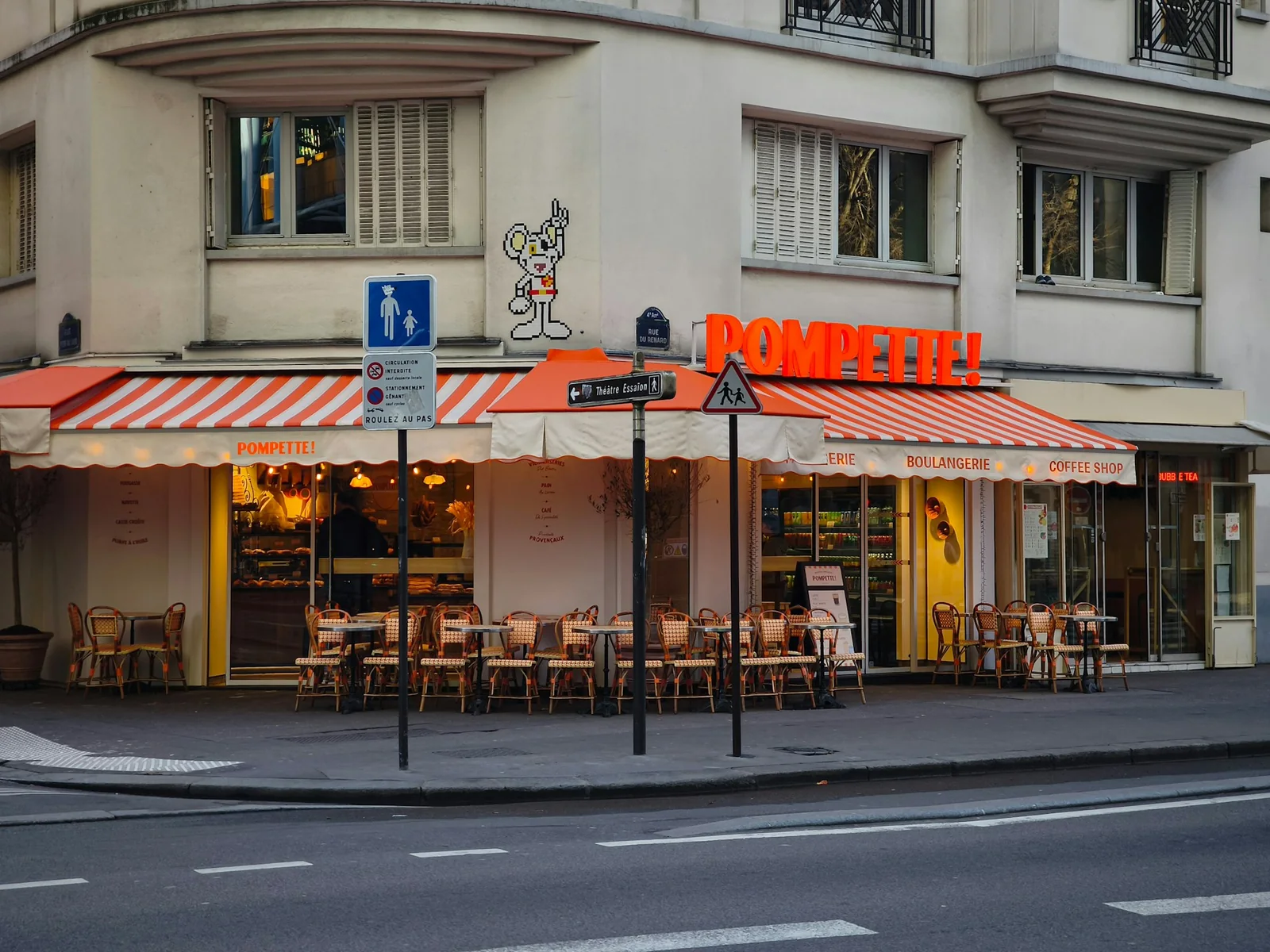 A Paris bakery and cafe with an awning and outdoor seating